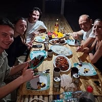 Group of friends sharing a meal at a cozy restaurant, highlighting local cuisine and travel experiences. Enjoying a delicious meal with friends during a trip to the Philippines.