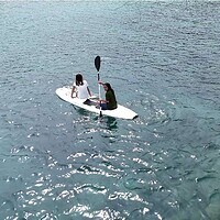 Enjoying a kayaking adventure in the beautiful waters of the Philippines. Two people kayaking on clear blue waters in the Philippines.