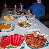 A young boy enjoying a traditional Filipino breakfast with eggs, fruits, and seafood, set on a table with various dishes. Enjoy a delicious traditional Filipino breakfast with eggs, fresh fruits, and seafood.