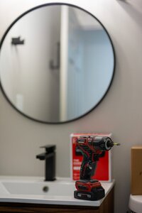 Power drill in bathroom setting used for home improvement projects or repairs.