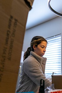 Modern woman unpacking boxes in a new house.