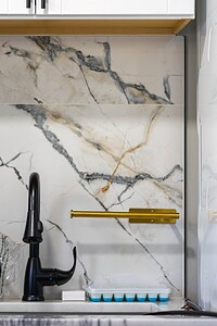 Kitchen backsplash with marble pattern and black faucet, modern kitchen design.