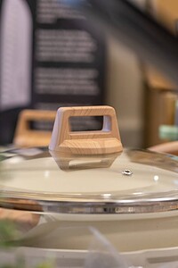 Close-up of a stylish wooden handle on a slow cooker lid, showcasing contemporary kitchen design elements.