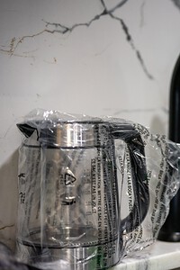 Close-up of black kitchen sink faucet with attached water filter in a modern kitchen.