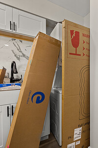 Bright, contemporary home entryway with under-construction features, white walls, and sleek cabinetry.