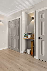 Custom home interior featuring neutral walls, stylish closet doors, and warm wood floors designed for comfort and elegance.