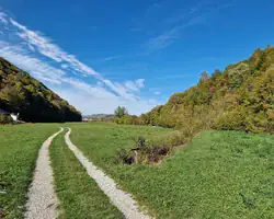 Krušnica rijeka okružena zelenim brdima i plavim nebom.