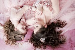 Mother and daughter posing elegantly in the studio. Studio portrait of mother with daughter in pink princess dresses – children’s photography NYC