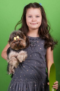 Portrait of a girl in a studio with green backdrop. Studio portrait of girl on green background – children’s photography NYC