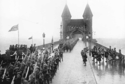 1st Division crosses the Rhine into Germany
1918 as occupation force. 15th Battalion Pipes and; Drums at right.