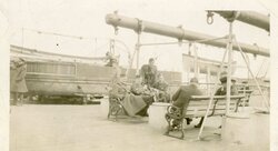 Officers relaxing on board RMS Baltic. Seated centre is Lt Smith a 2nd Ypres POW. Kneeling right is Lt JE Banton ?. Seated left is Maj Mackenzie (MO)? Standing is ?