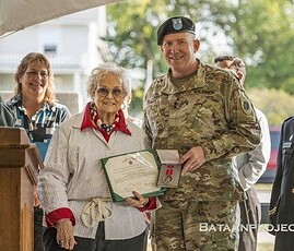 Clara Spencer-Fidler, the sister of Sgt, Norman Spencer receives his Bronze Star from Major General Richard J. Hayes Jr., Adjutant General of the Illinois National Guard. Clara Spencer-Fidler, and Major General Richard J. Hayes Jr