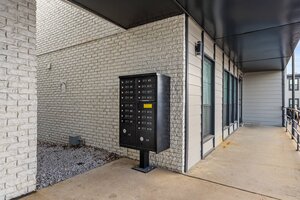 Modern apartment building exterior with secure multi-unit mailbox system and modern architecture.