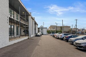 Apartment building parking lot with modern design and city view, ideal for urban residents.