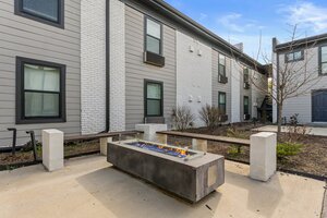 Outdoor fire pit area in apartment complex featuring contemporary design and landscaped surroundings.