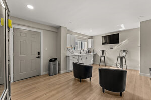 Modern basement with kitchen, TV, and comfortable seating area.