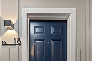 Elegant navy entrance door with contemporary black handle and house number 16.