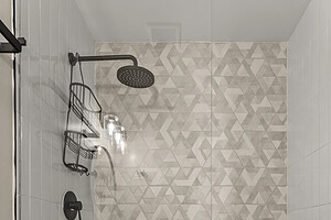 Elegant walk-in shower featuring contemporary geometric wall tiles and a sleek black showerhead.