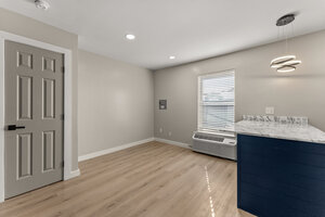 Bright living space featuring neutral walls, light wood flooring, and stylish LED pendant lighting.