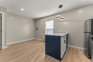 Bright modern kitchen features a stylish island and stainless steel appliances, perfect for contemporary living.