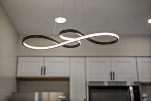 Contemporary black and white LED loop chandelier in a stylish kitchen.