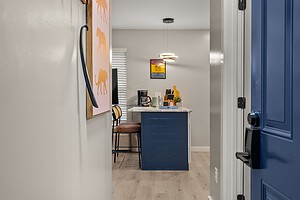 Cozy home kitchen with modern design, featuring a chic blue door and artwork on the wall.