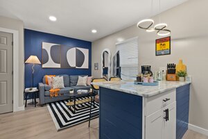 Bright living room with contemporary design, blue accent wall, and cozy decor elements.