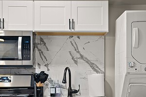 Bright, stylish kitchen featuring white cabinets and modern appliances for home cooking.