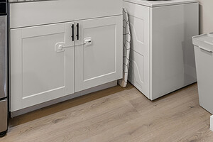 Versatile laundry room featuring stacked washer and dryer, sleek white cabinets, and a spacious sink.
