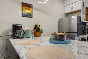 Stylish modern kitchen featuring coffee machine, toaster, and stainless steel refrigerator for everyday convenience.