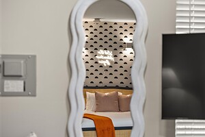 Stylish hotel bedroom with contemporary decor, cozy bedding, and decorative wall accents.