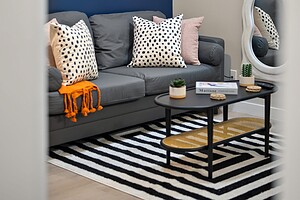 Elegant living space featuring a blue accent wall, abstract artwork, and trendy decor elements.