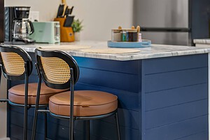 Kitchen island with two modern bar stools and sleek pendant lighting for stylish interiors.