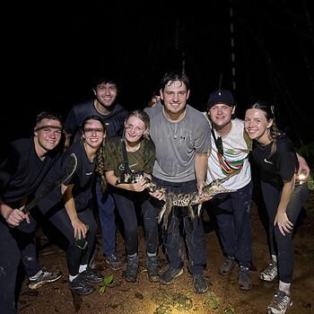 Group holding small crocodile night 2026 05