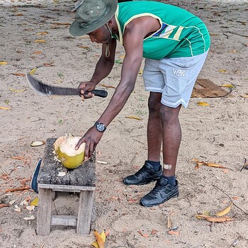 Man cutting coconut with machete outdoor