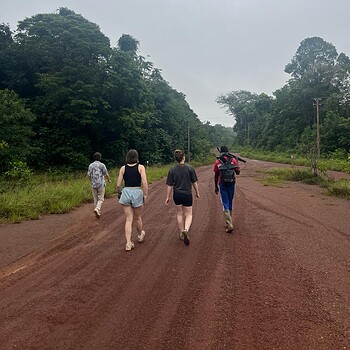 People walking red dirt road forest 2026 05