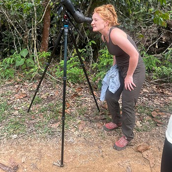 Photo redhead woman spotting scope forest 2026 05