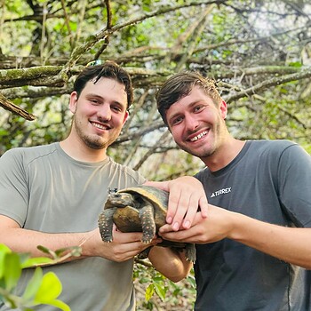 Two men holding tortoise 2026 05