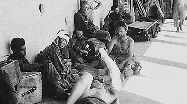 An Army medic gives medical treatment and talks with freed POWs. Cabanatuan Former POWs