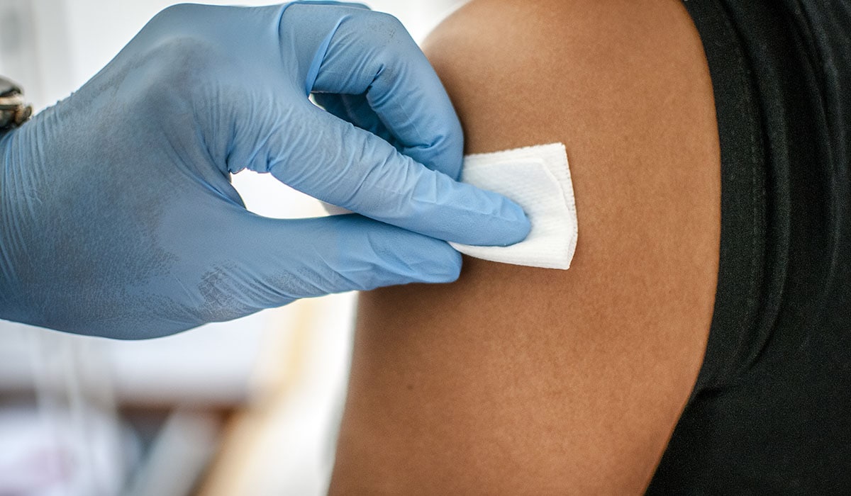 Doctor Disinfects Skin Of Patient Before Vaccination