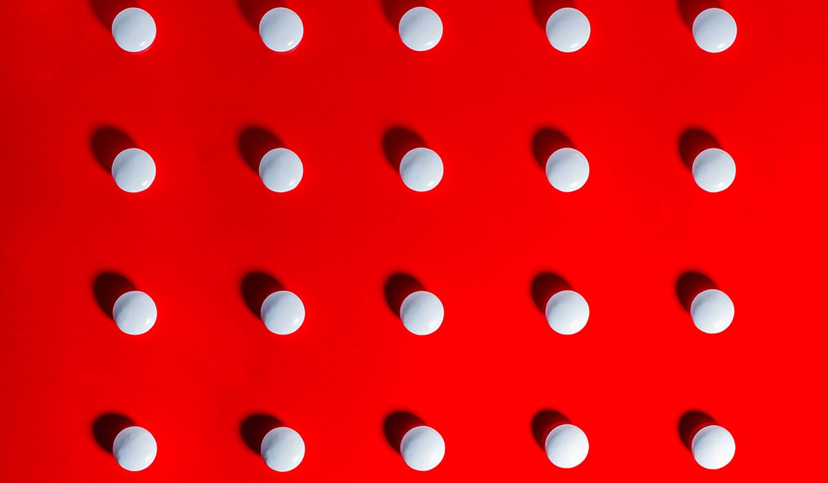 White Pills Against Red Background