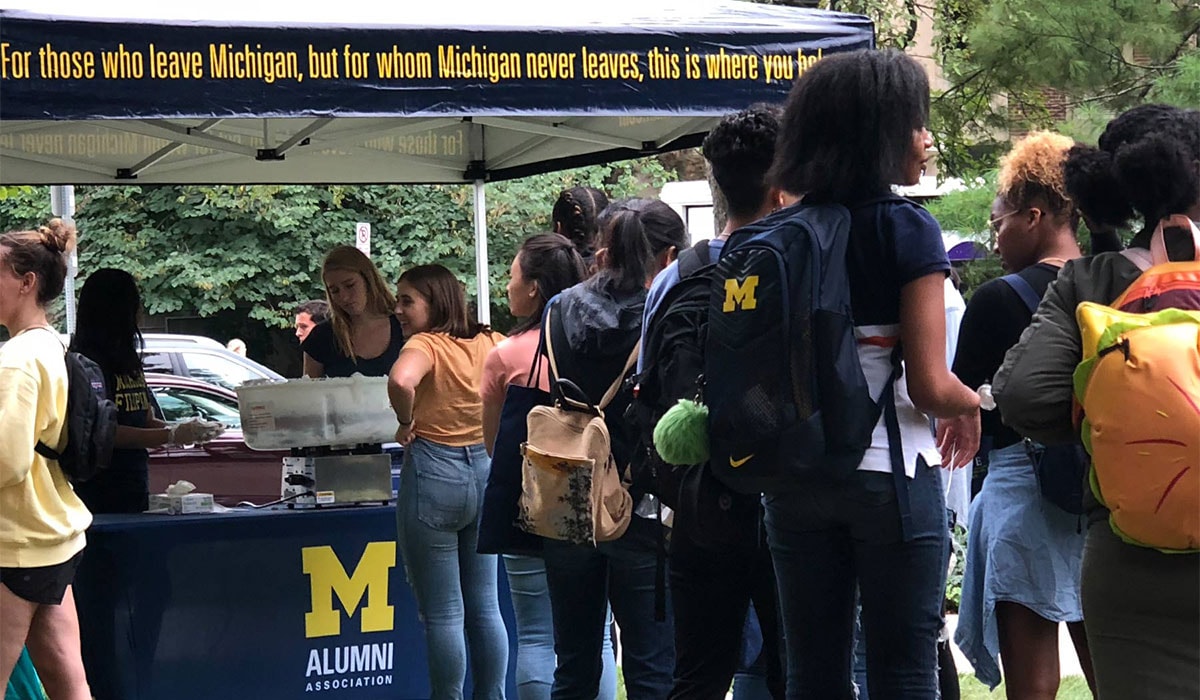Students outside an Alumni Association tent at the University of Michigan