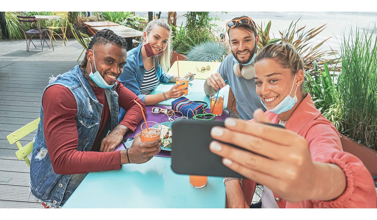 Friends Takeing Selfie In A Bar Restaurant With Face Mask On In Coronavirus Time Young People Having Fun With Drinks And Snacks Outside With New Rules After Virus Break
