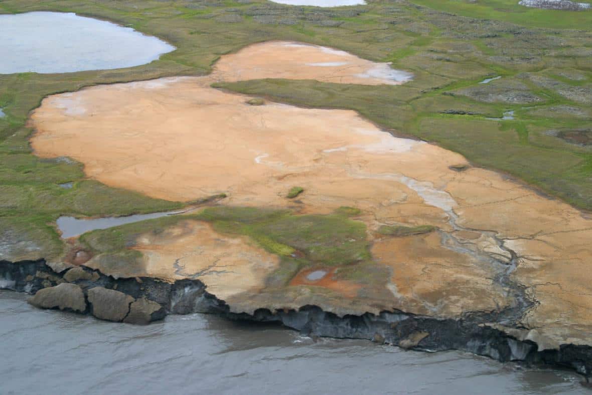 An oblique aerial photograph of Flaxman Island off the Alaska coast. A tapped thermokarst lakes, caribou tracks, and ice-rich bluffs that are eroding can be observed in this photo. Photo: Bruce Richmond/Ann Gibbs, USGS. Public domain.