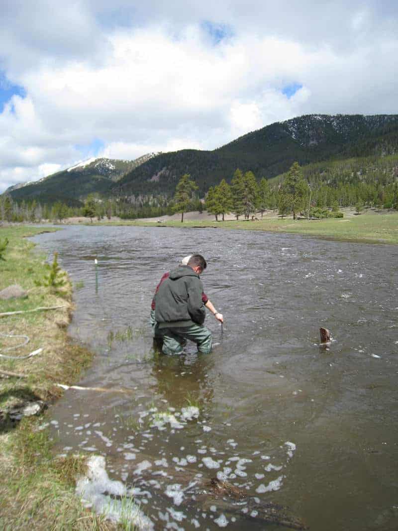 USGS employees deploys a water conductivity/temperature/depth probe (AquaTroll) for a temporary study along the Madison River, Yellowstone.