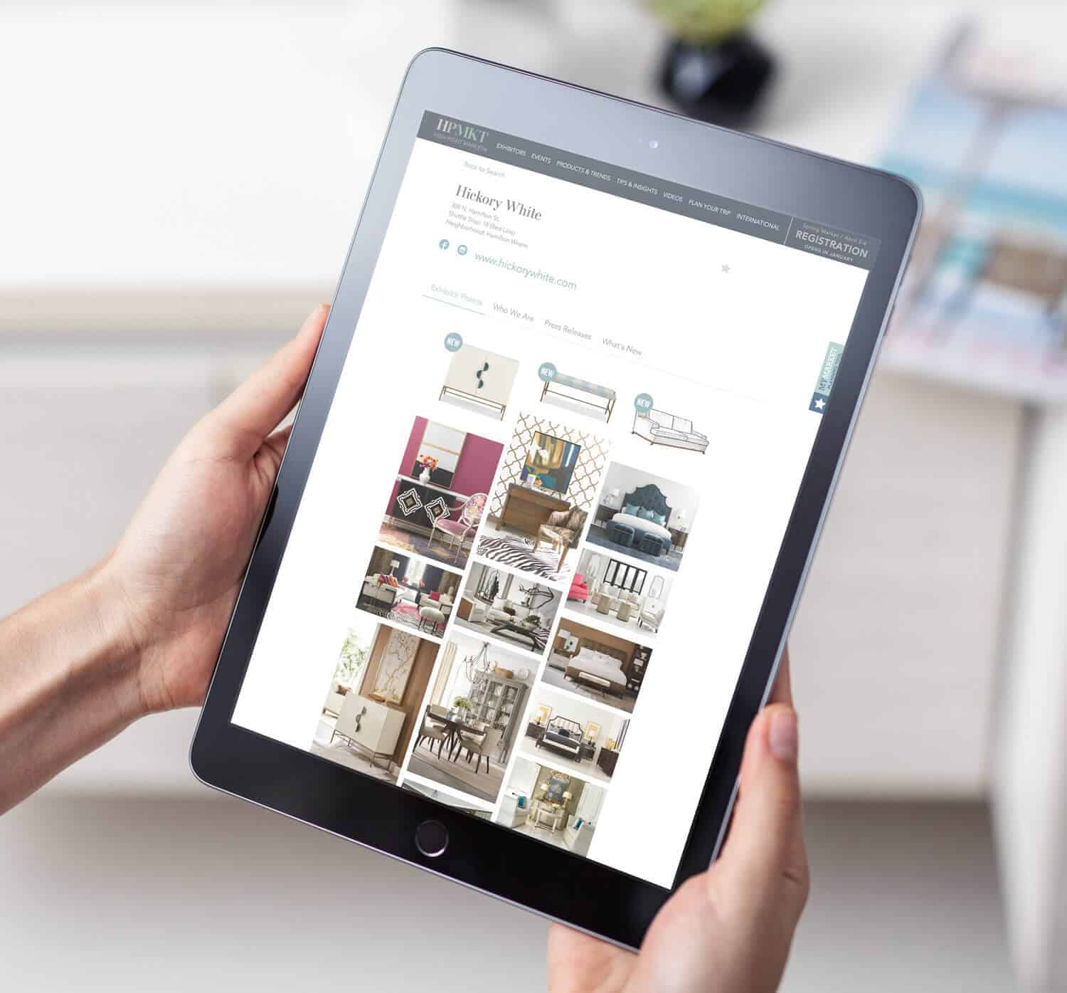 hands holding an ipad that shows the High Point Market exhibitor profile page. The page has a clean design and show a grid of product photos