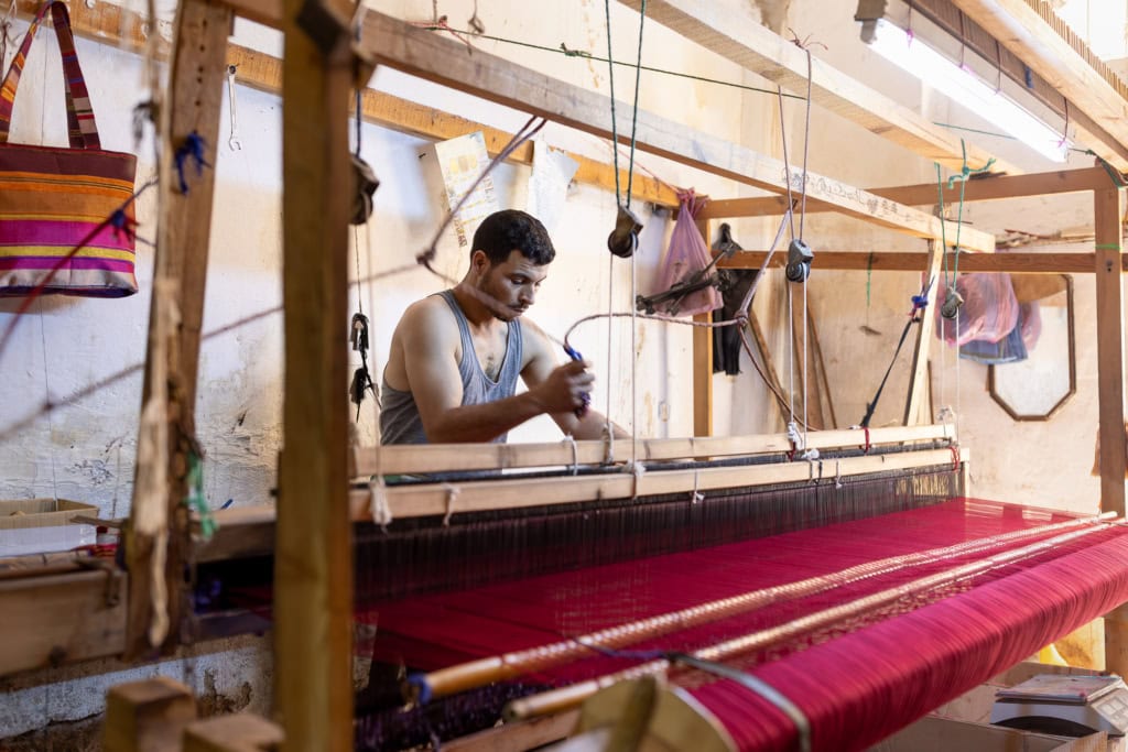 Fez, Morocco, has a long tradition of arts and crafts. I visited and photographed artisans from a variety of fields in their workshops. Weaver at a traditional loom.