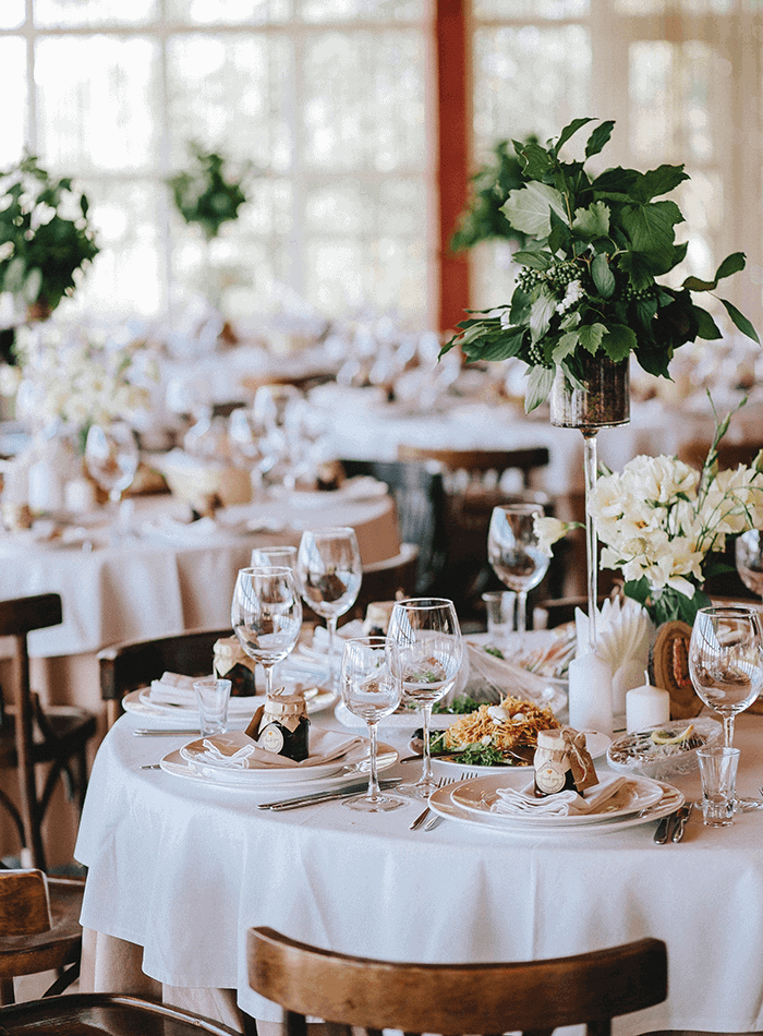Beautiful wedding reception table decorated with fresh flowers and elegant glassware in Thailand.