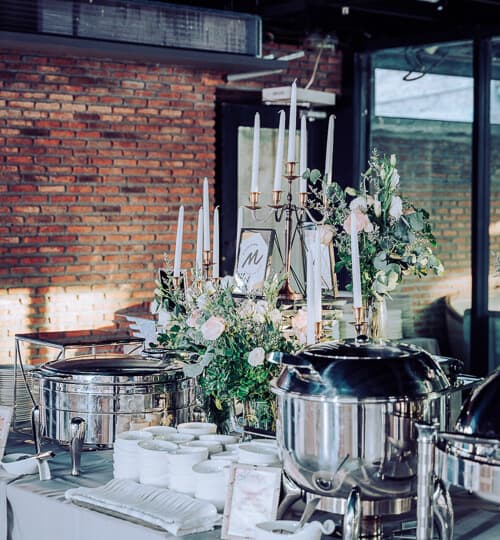 Beautiful buffet table with flowers and candles, perfect for wedding or banquet events in Thailand.