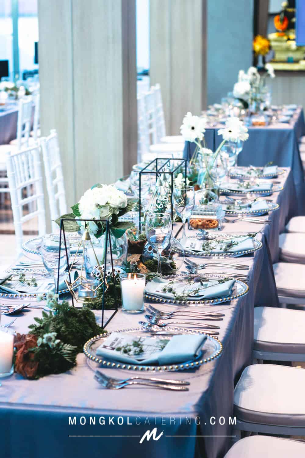 Elegant wedding banquet table setup with white floral centerpieces in Thailand.